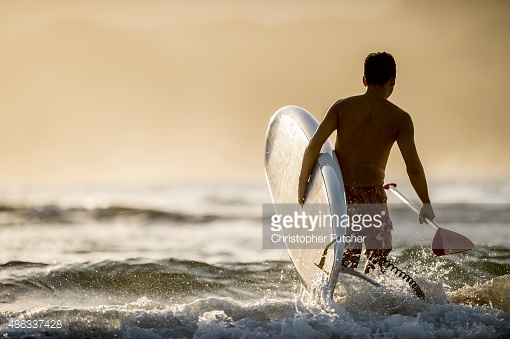 486337428-man-going-into-the-surf-gettyimages